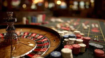 A man celebrating a winning moment on his laptop while gaming symbols float around him, capturing the excitement of JLJL10PH games.